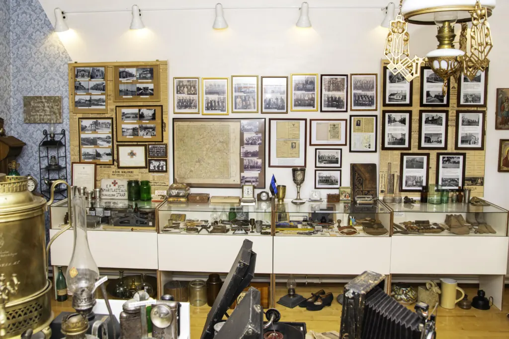 Tapa Muuseumi väljapanek seinal olevate raamitud fotode ja vitriinidega